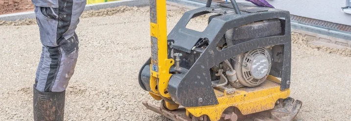 Person verwendet Rüttelplatte